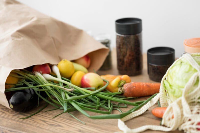 Nuotrauka rodo ekologiškus maisto produktus, įskaitant šviežius vaisius ir daržoves, kurie yra natūraliai užauginti ir neturi cheminių priedų.